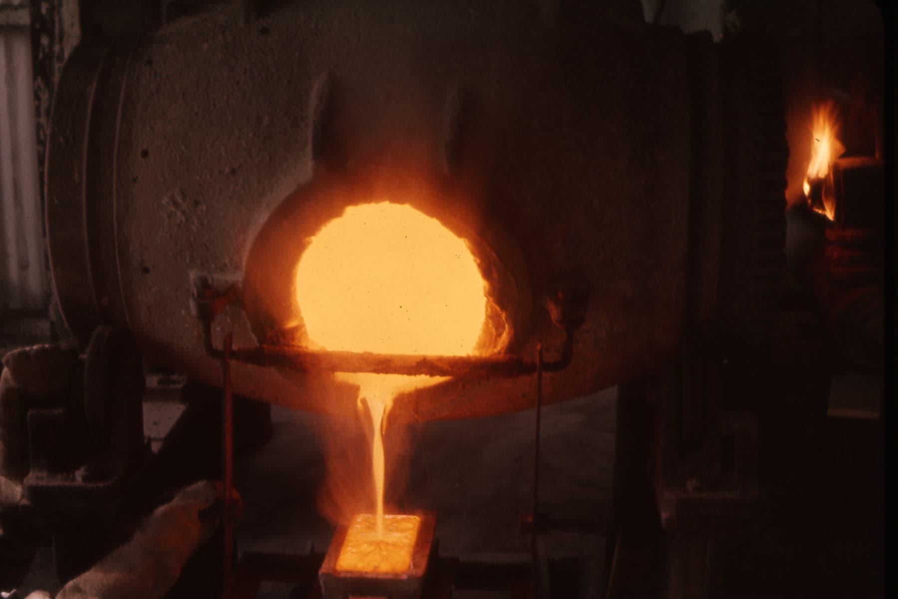 Molten gold being poured into a bar mould at the furnace